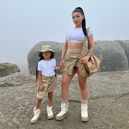 estefania fernandez and daughter standing on rocks wearing matching white ugg boots